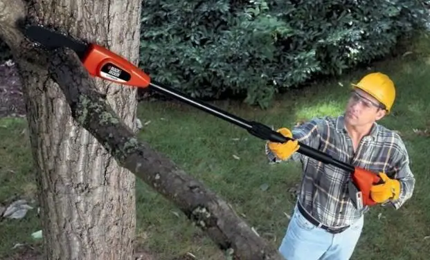 man with electric pole saw